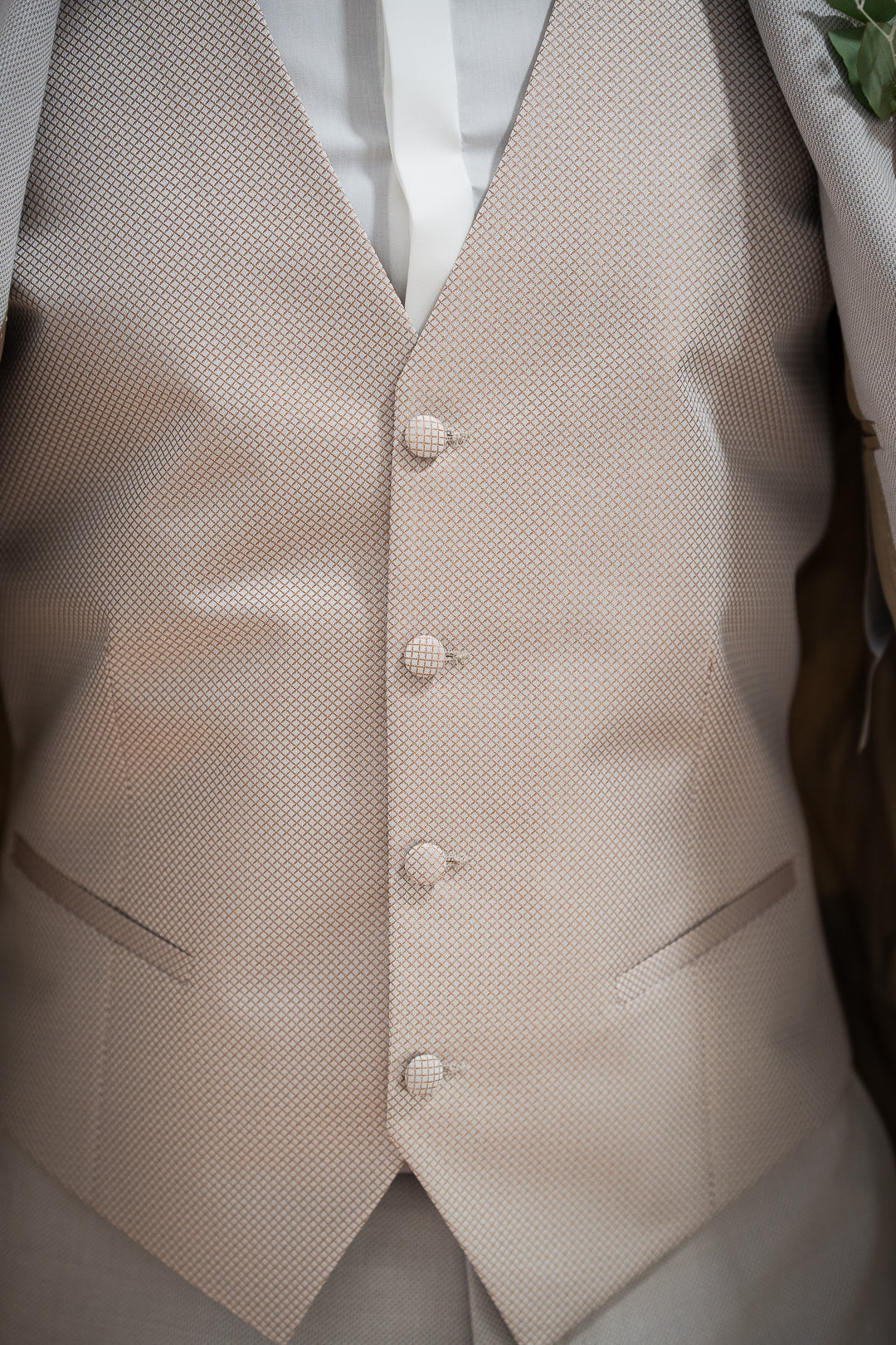 Détail gilet beige, parfait pour un mariage ou toute autre cérémonie spéciale. Sa texture subtile et sa couleur neutre apporteront une touche de sophistication à votre tenue. Le tissage fin et raffiné offre un confort optimal tout au long de la journée, tandis que les boutons discrets ajoutent une note d'élégance intemporelle. Ce gilet s'adapte à toutes les morphologies et se combine facilement avec une chemise blanche et un costume pour une allure classique et raffinée.