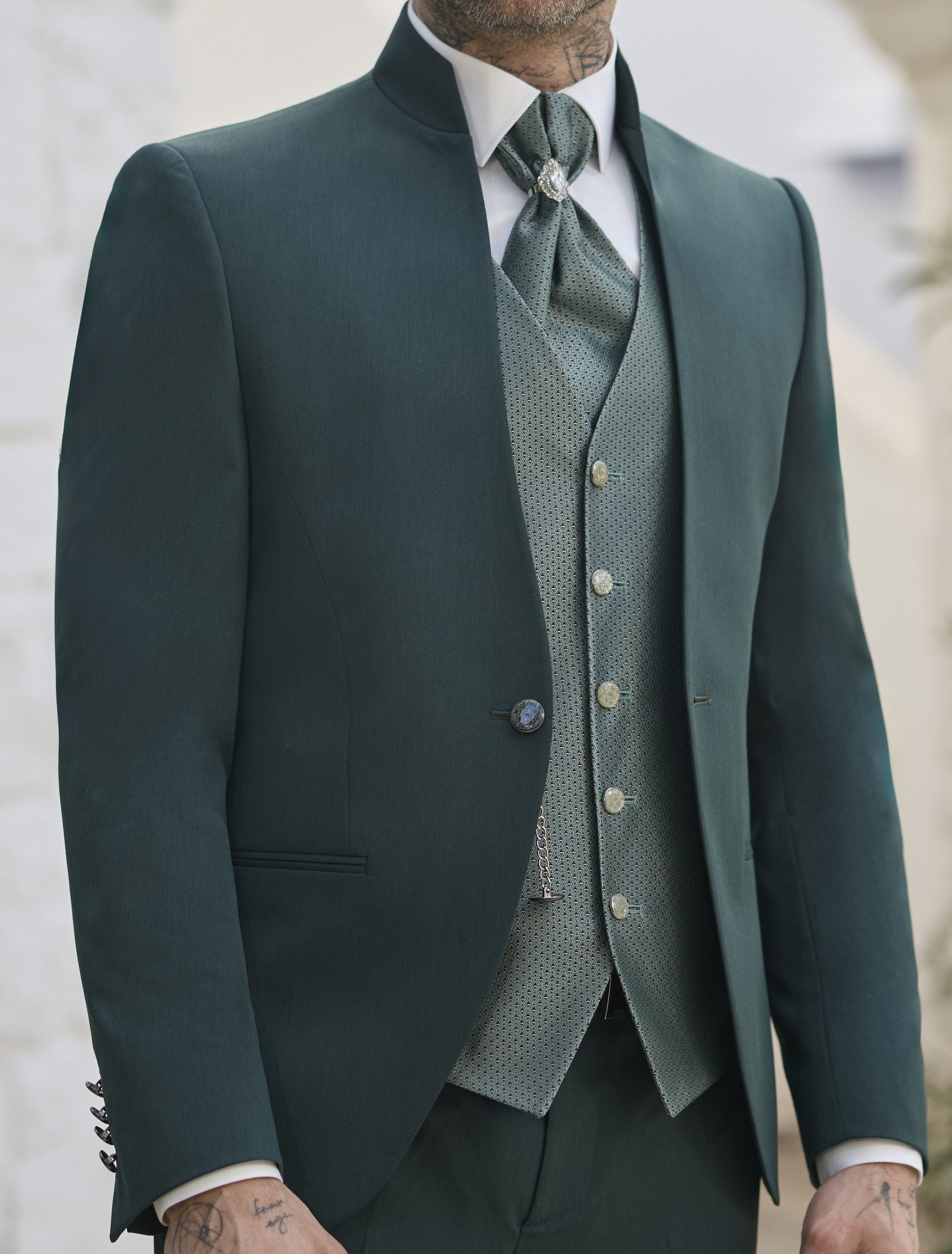 Détail costume vert sapin homme, col officier, avec gilet et lavallière à motifs.