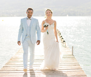 couple de marié sur ponton au bord du lac d'Aix-les-Bains jeune homme métisse portant un costume de mariage bleu ciel et d'une mariée portant un robe fluide ivoire