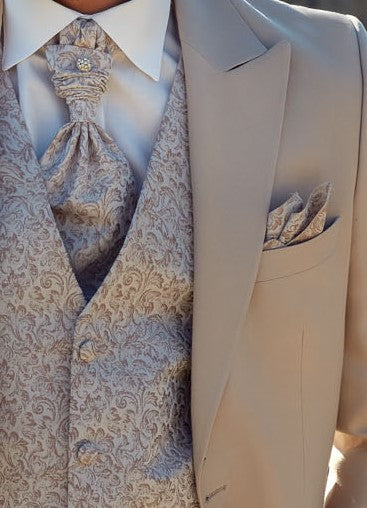 détail d'un costume de marié beige. La veste et le pantalon sont unis beige et le gilet avec des motifs floraux assorti à une cravate 