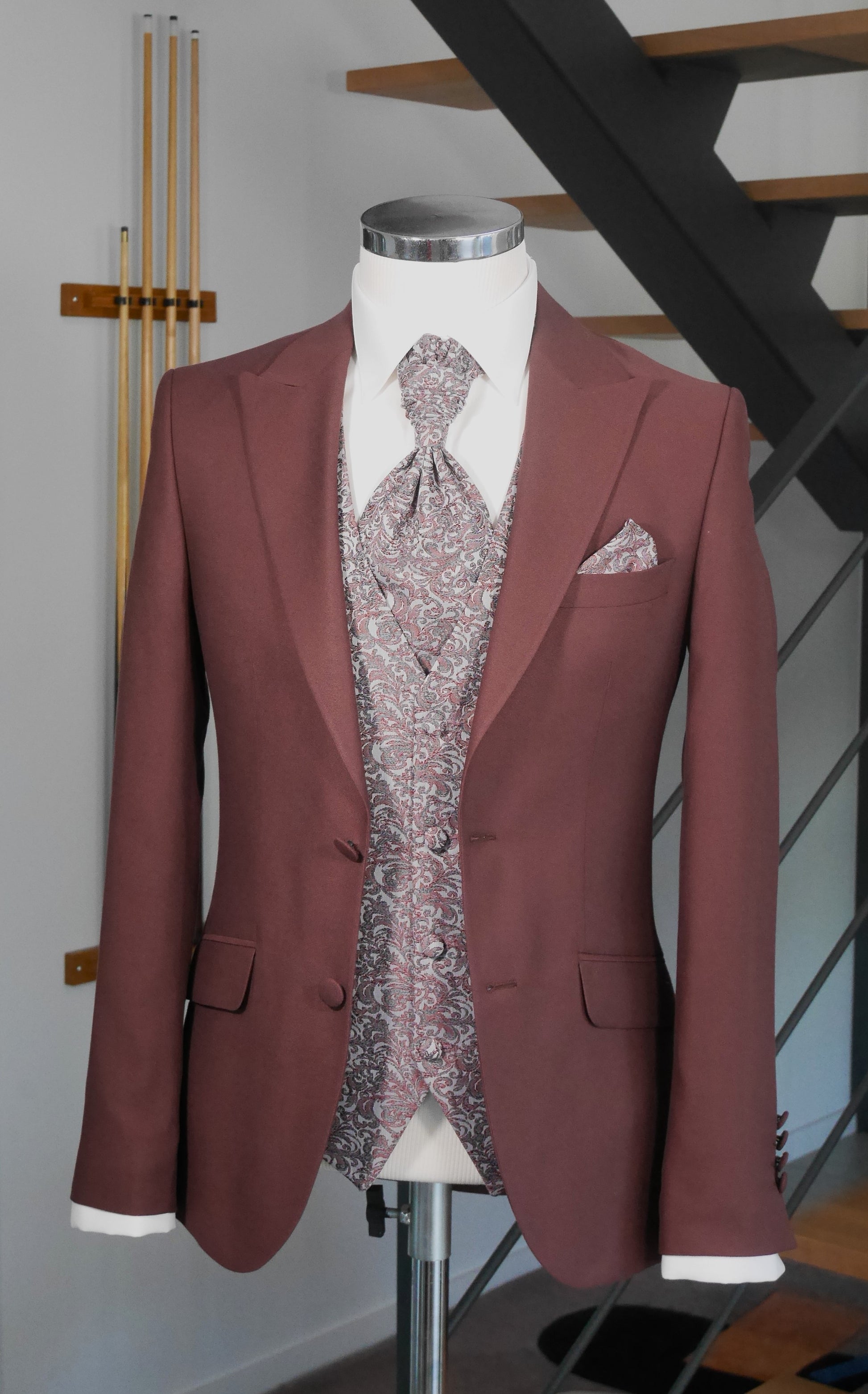 buste  portant un costume de marié bordeaux veste unie bordeaux gilet à motifs floraux gris clair et bordeaux cravate assortie au gilet