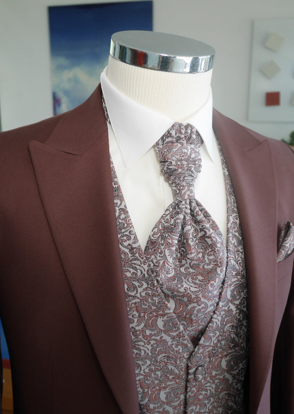 détail d'un costume de marié bordeaux veste  uni bordeaux gilet à motifs floraux gris clair et bordeaux cravate assortie au gilet