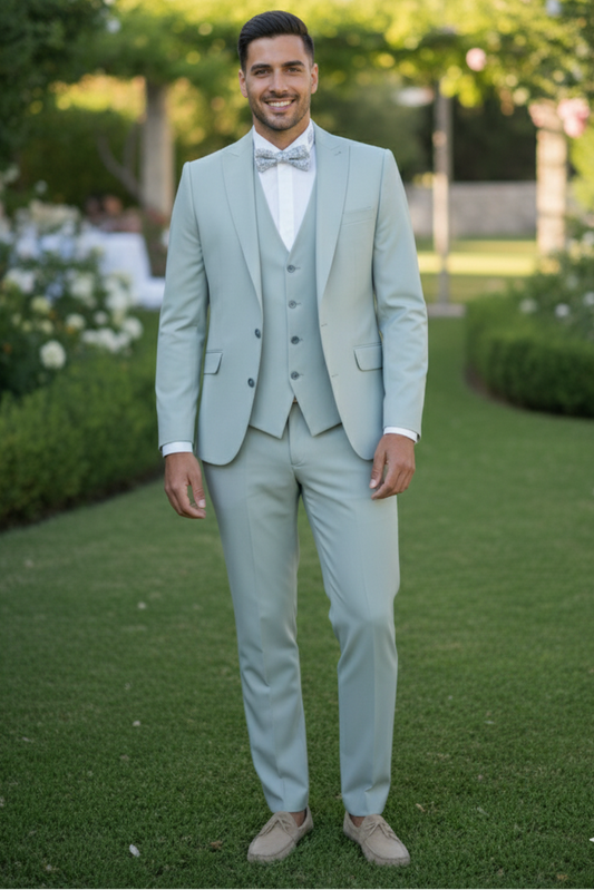 Marié en costume 3 pièces vert d'eau, tissu extensible, avec nœud papillon, posant dans un jardin champêtre Sweet Tailor